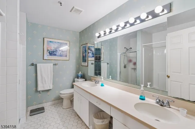 a spacious bathroom with a tub a double vanity sink a mirror a shower and a bathtub