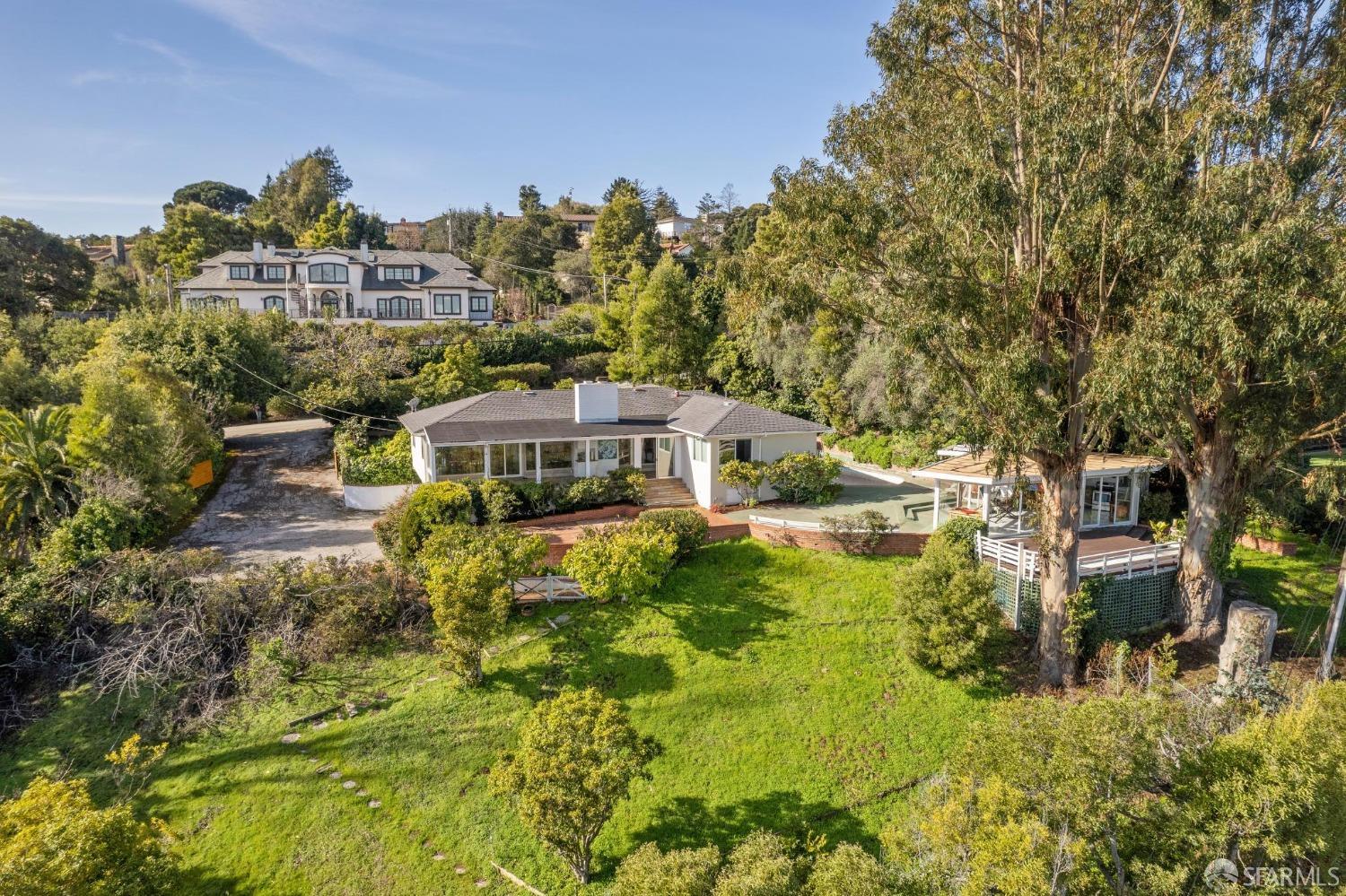 2480 Summit Drive Hillsborough, CA 94010 - Photo 1 of 12 a aerial view of a house with a big yard with potted plants and large trees