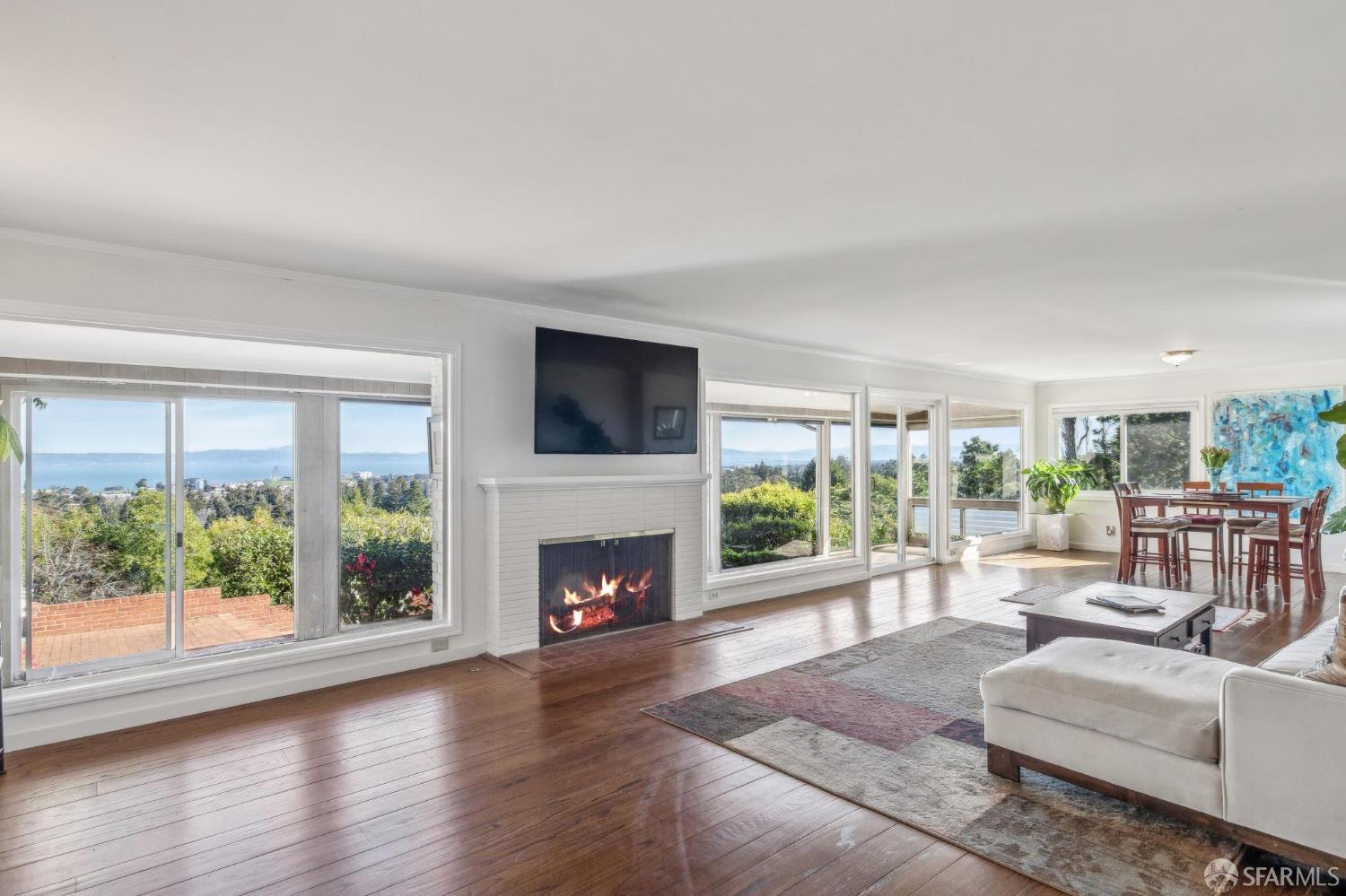 2480 Summit Drive Hillsborough, CA 94010 - Photo 7 of 12 a living room with furniture a fireplace and a floor to ceiling window