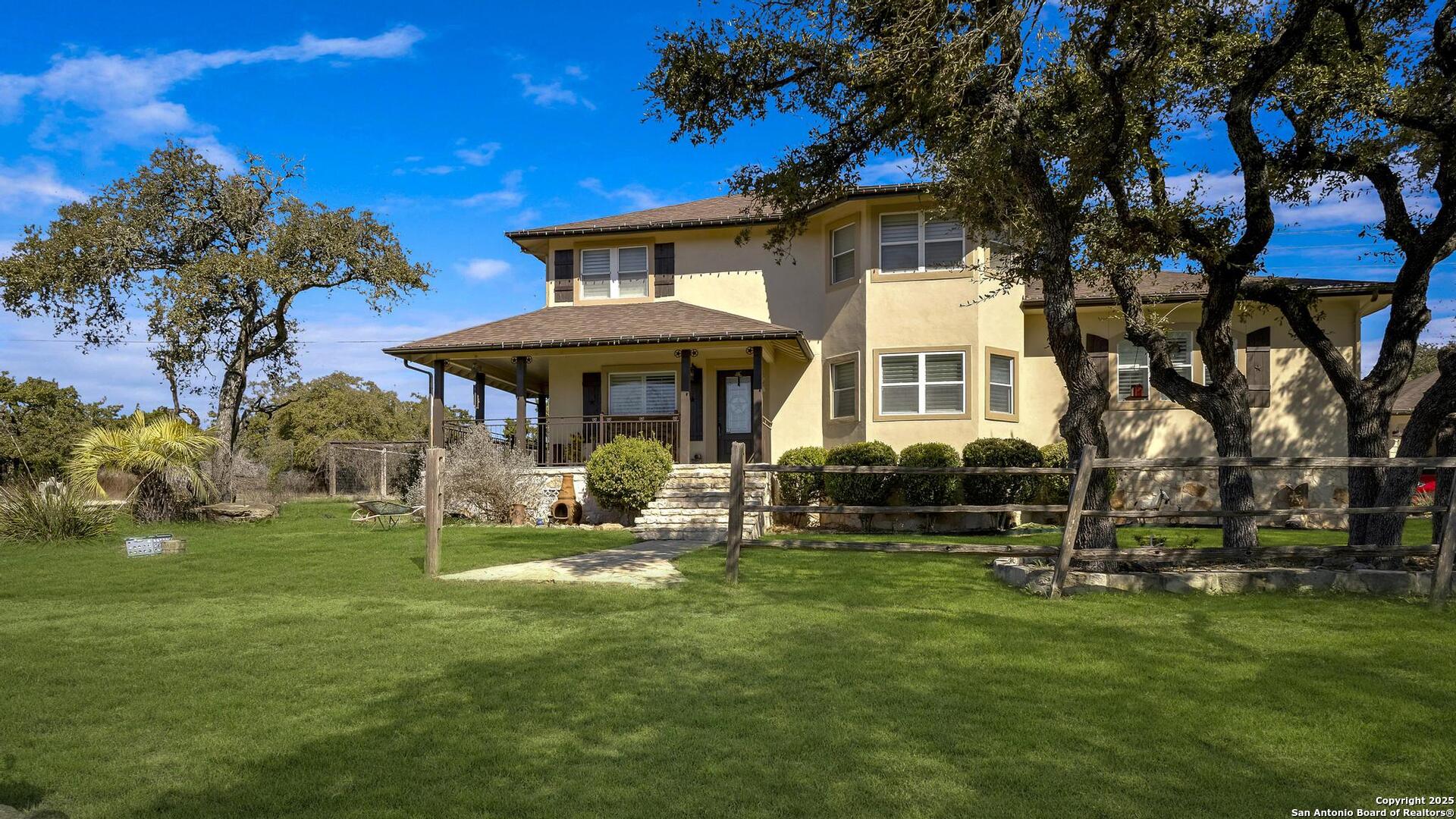 15090 Highway 46 Spring Branch, TX 78070 - Photo 4 of 71 a front view of a house with a yard table and chairs