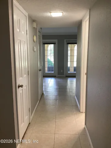 a view of a hallway with wooden floor and a living room