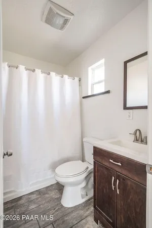 a bathroom with a sink a toilet and a mirror