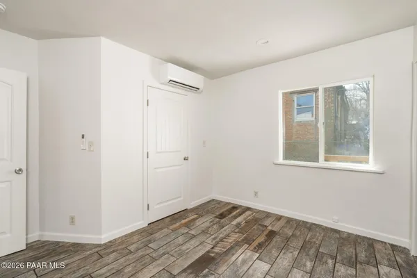 a view of a room with wooden floor and a window