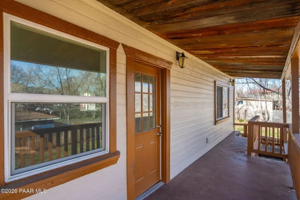 a view of a porch with furniture and floor to ceiling window