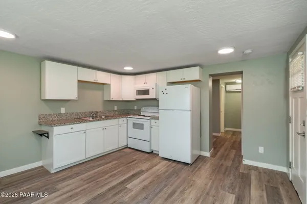 a kitchen with a refrigerator and white cabinets