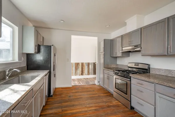 a kitchen with stainless steel appliances granite countertop a sink stove and refrigerator