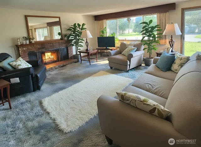 a living room with furniture fireplace and large windows