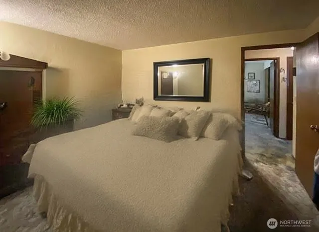 a bedroom with a bed and a potted plant