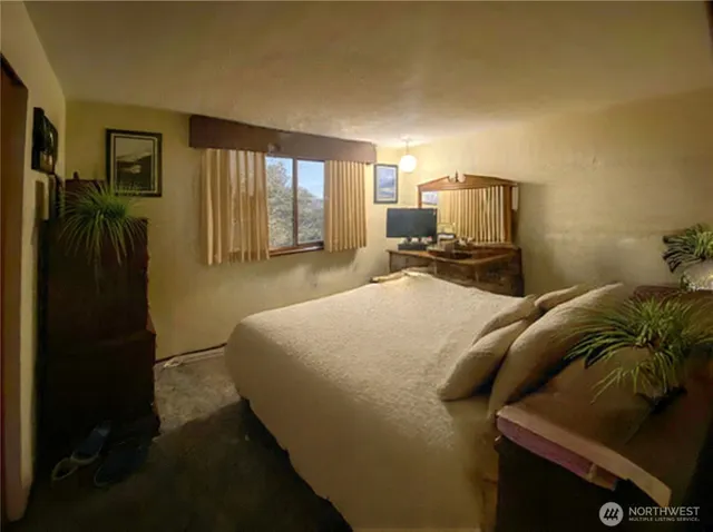 a bed sitting in a bedroom next to a window