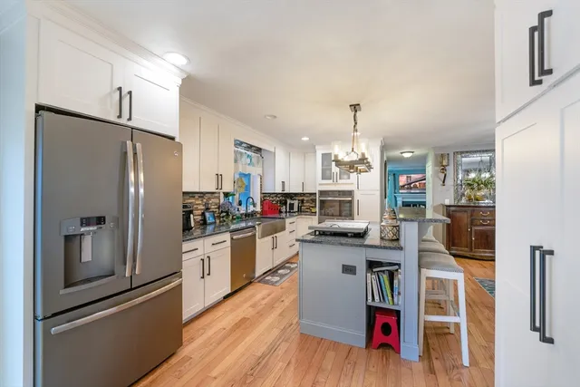 a kitchen with stainless steel appliances granite countertop a refrigerator and a stove