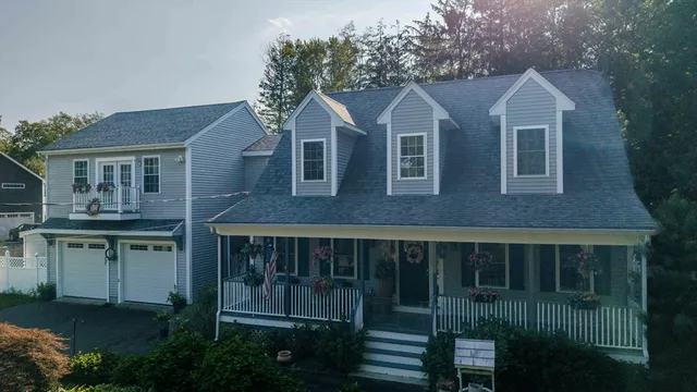 a view of a brick house with large windows and a small yard