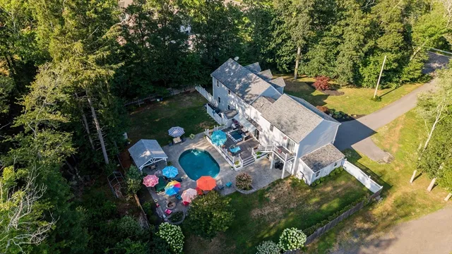 an aerial view of a house with a yard swimming pool and outdoor seating