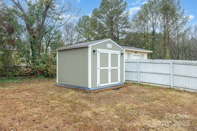 a view of a house with a yard and large tree