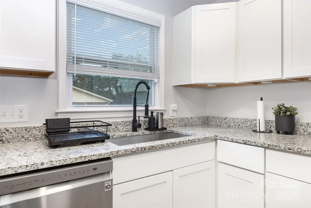 a kitchen with granite countertop a sink and cabinets
