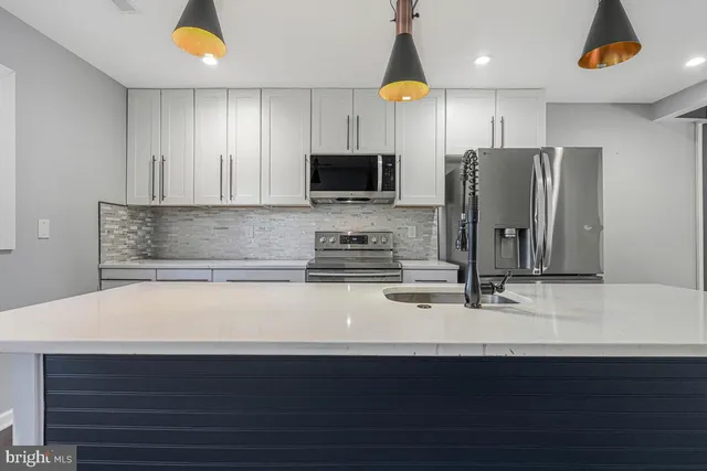 a kitchen with stainless steel appliances a refrigerator a sink a stove a microwave and wooden cabinets