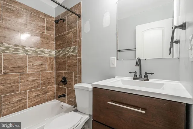 a bathroom with a sink toilet vanity and shower