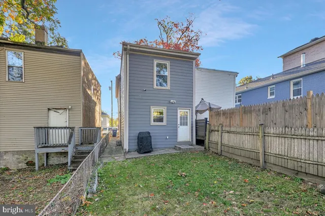 a view of backyard with barbeque grill and wooden fence