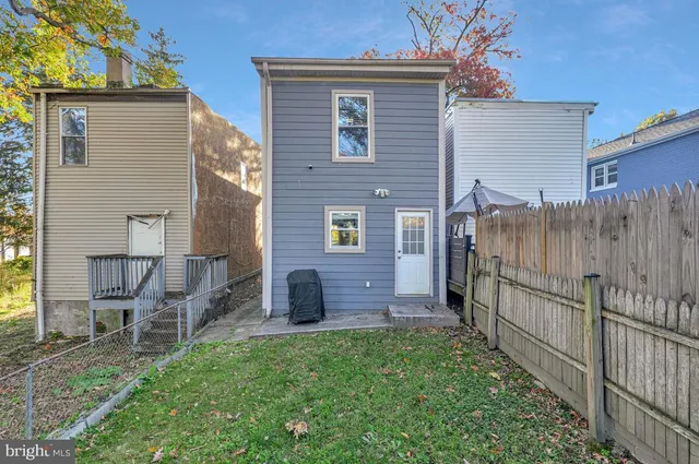 a view of a brick house with a yard and table and chairs