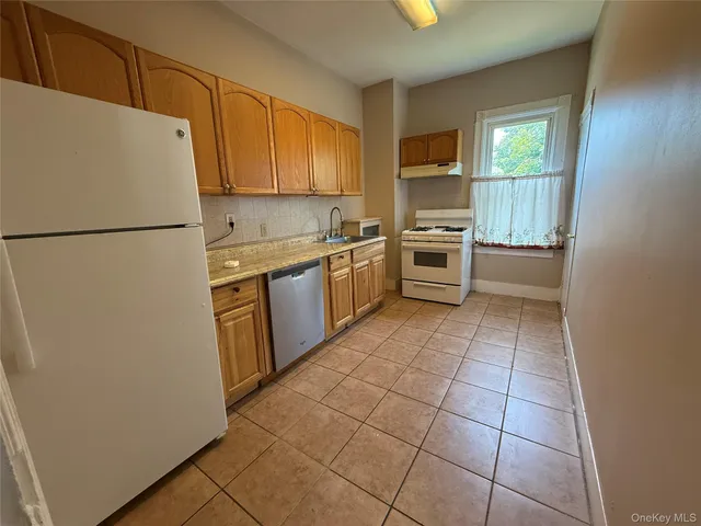 a kitchen with a stove a refrigerator and a sink