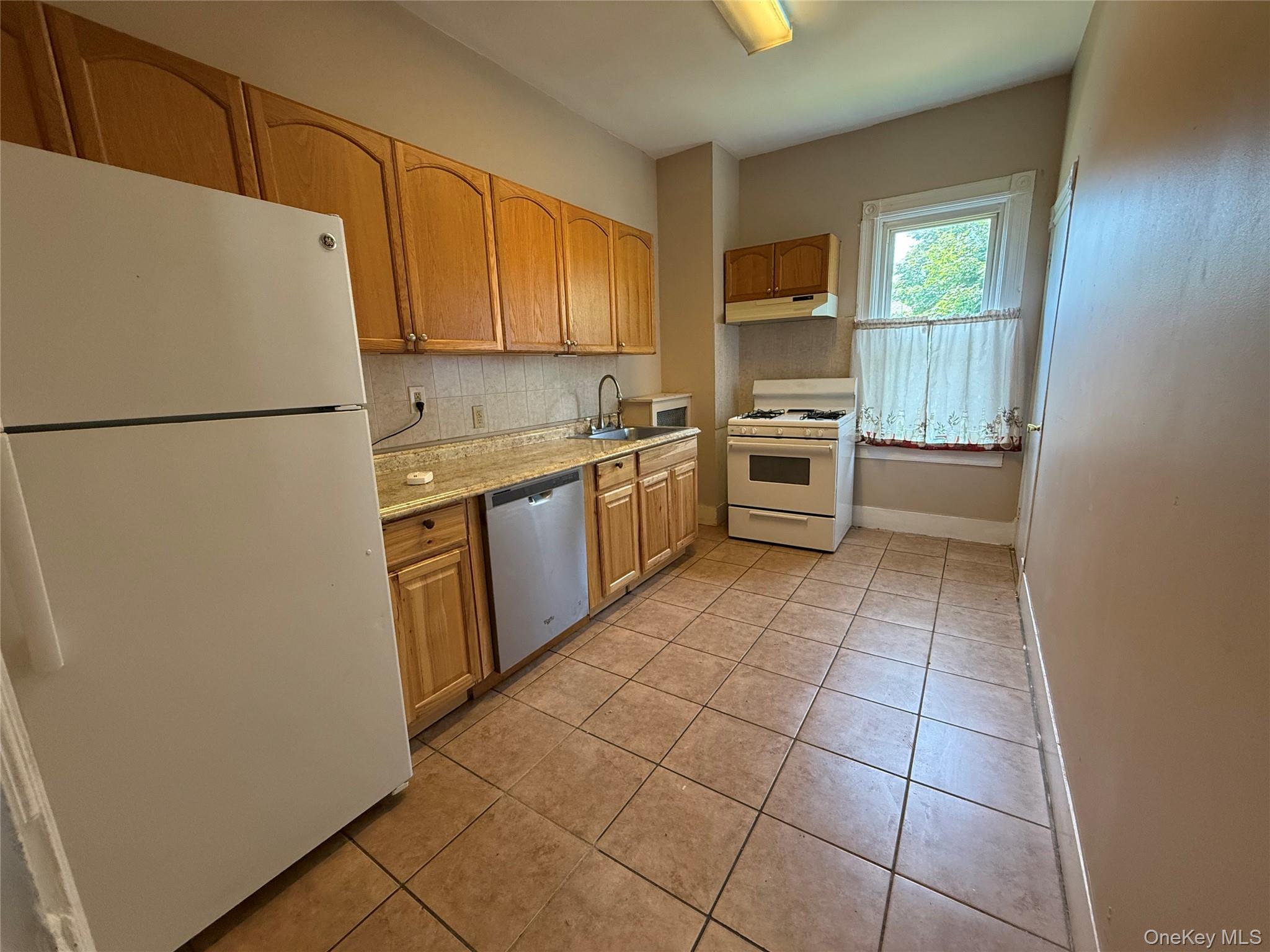 a kitchen with a stove a refrigerator and a sink