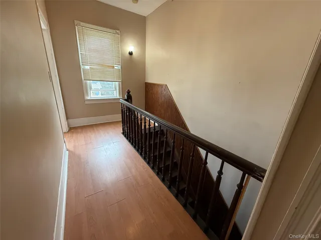 a view of a hallway with wooden floor and stairs