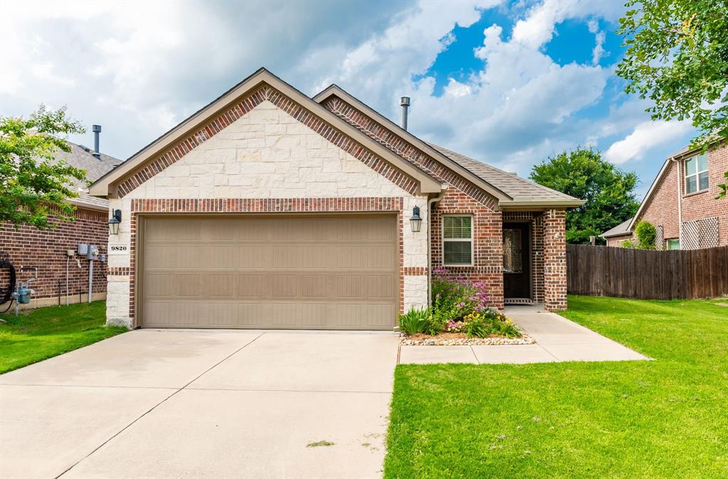 View of front of house with brick siding, concrete driveway, an attached garage, and a shingled roof