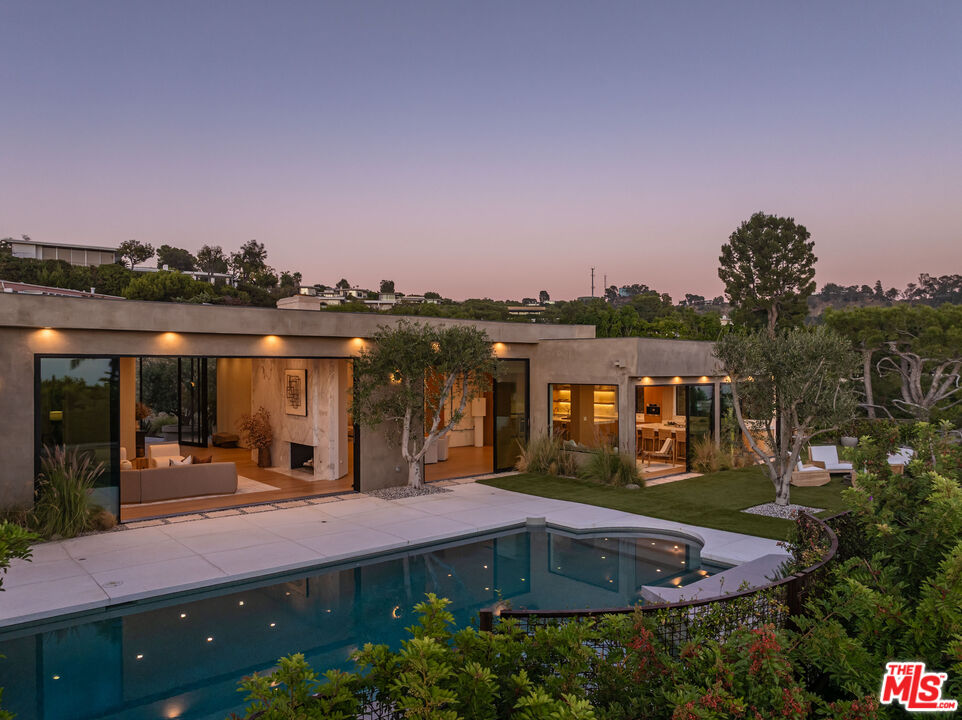 a front view of a house with a garden and lake view