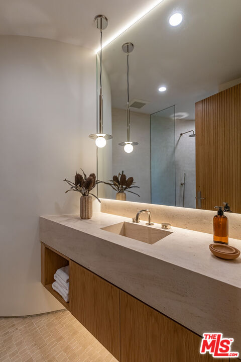 1705 Carla Ridge Beverly Hills, CA 90210 - Photo 28 of 53 a bathroom with a sink and a mirror