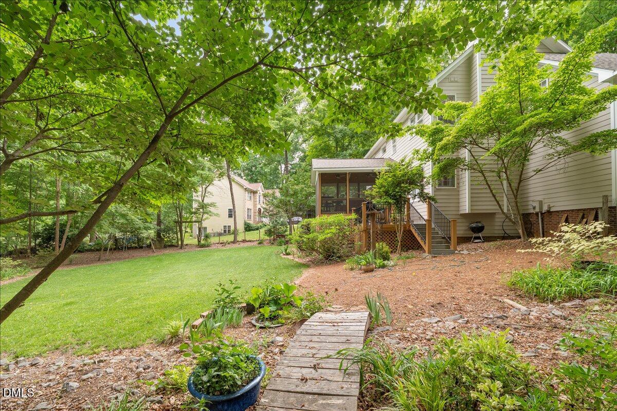 109 Hemingway Forest Place Raleigh, NC 27607 - Photo 24 of 33 a view of a patio with table and chairs potted plants and large tree