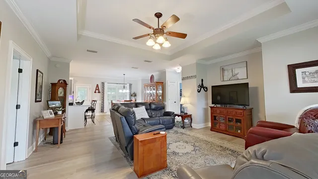 a living room with furniture and a flat screen tv with wooden floor