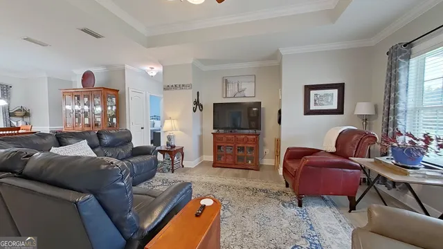 a living room with furniture a large window and a flat screen tv