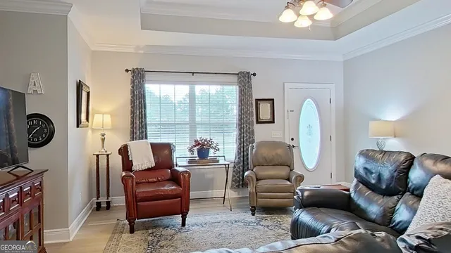 a living room with furniture a large window and a chandelier