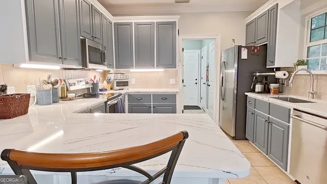 a kitchen with stainless steel appliances kitchen island granite countertop a refrigerator a sink a stove with wooden cabinets