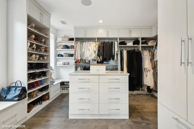 a view of walk in closet with clothes and shoes