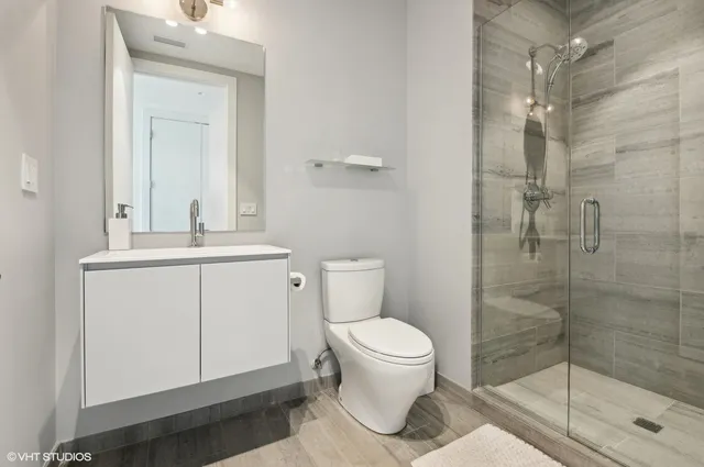 a bathroom with a sink a toilet and shower