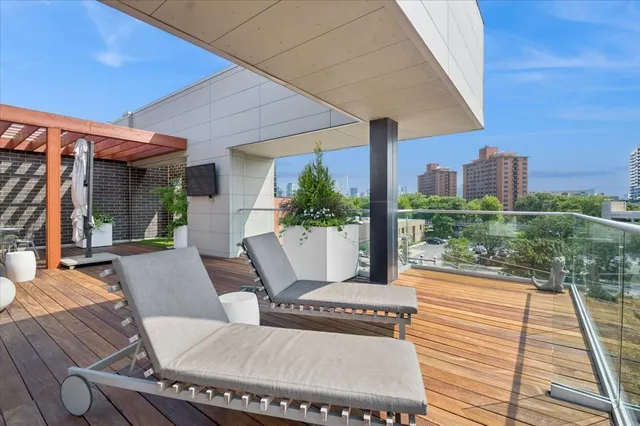 a view of a patio with couches chairs potted plants and wooden floor