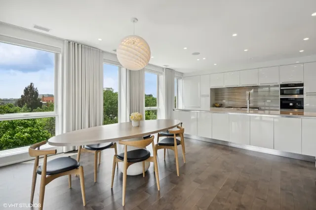 a kitchen with stainless steel appliances a table and chairs in it