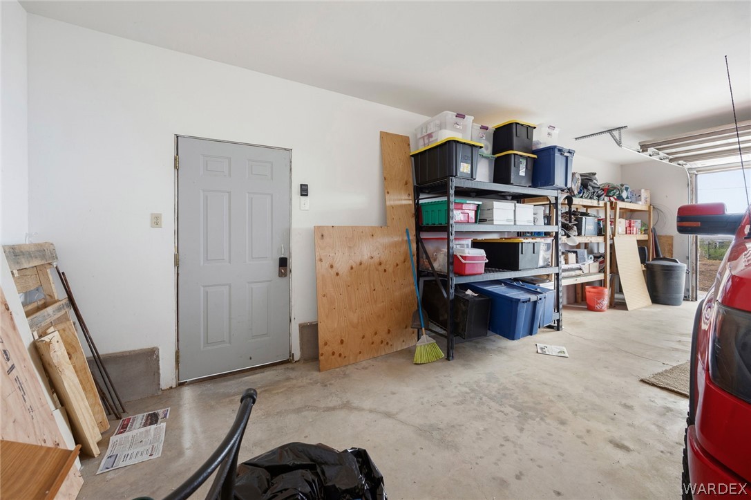 2465 Egar Road Golden Valley, AZ 86413 - Photo 46 of 98 The garage features a concrete floor, white painted walls, and an overhead door