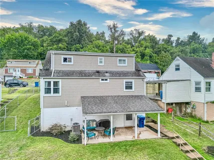 an aerial view of a house with pool and a yard