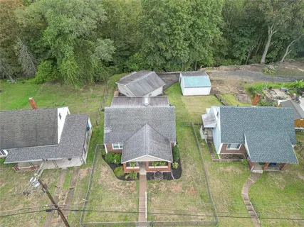 an aerial view of a house with swimming pool and a yard