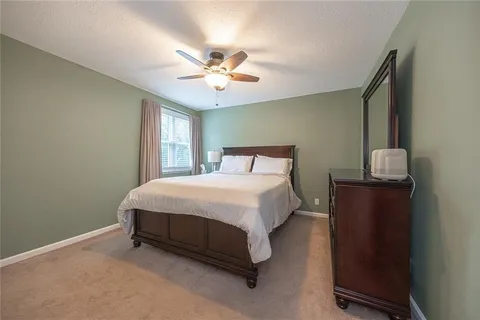 a spacious bedroom with a bed and a chandelier