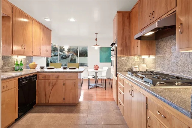 a kitchen with kitchen island granite countertop lots of counter top space and stainless steel appliances