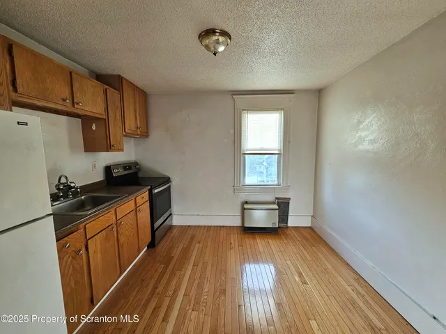 a kitchen with a sink and wooden floor