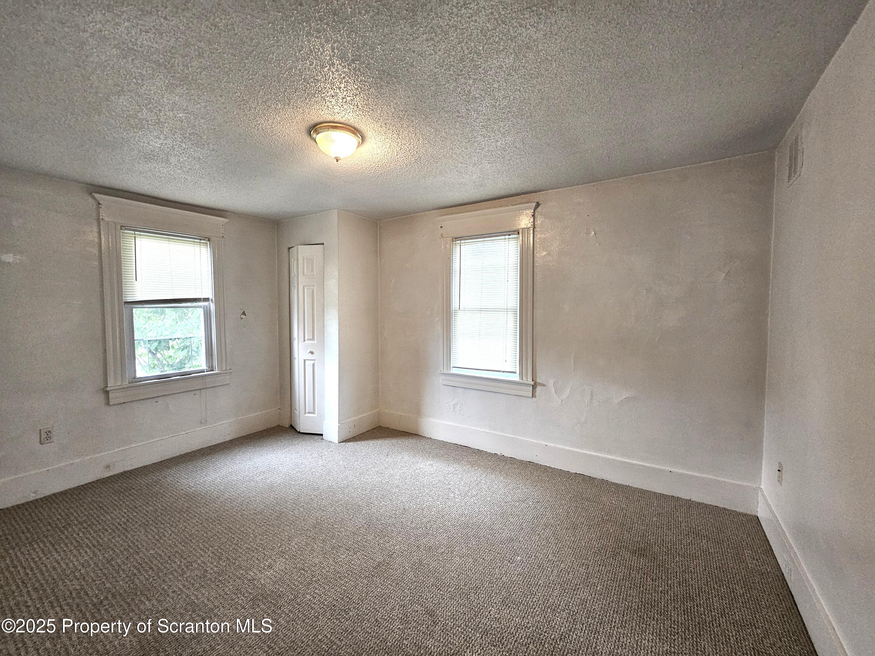 216 Elizabeth Street, Unit 2 Dunmore, PA 18512 - Photo 3 of 6 an empty room with windows