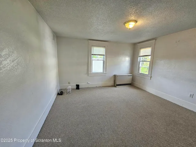 an empty room with windows and closet