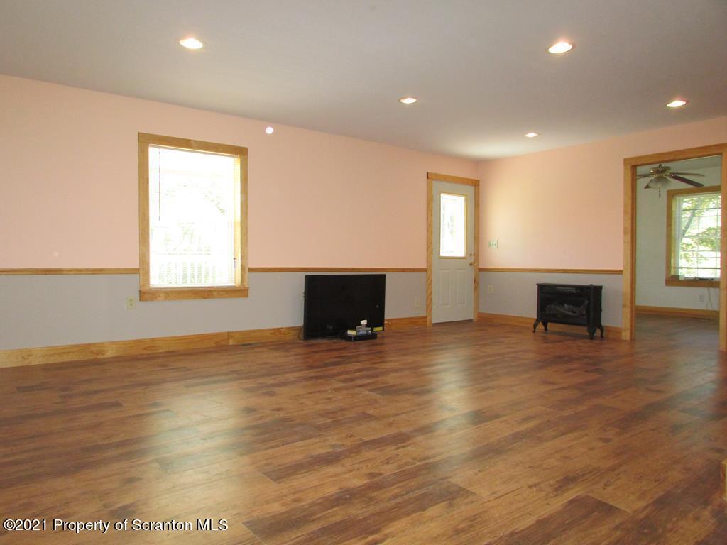 3328 Homets Ferry Road Wyalusing, PA 18853 - Photo 6 of 26 an empty room with wooden floor and fireplace