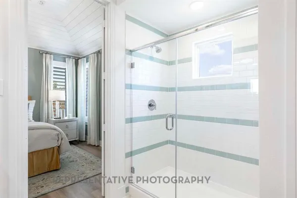 a bathroom with a glass shower door and a window