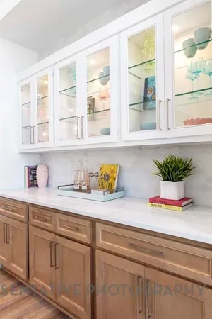 a white kitchen with kitchen island a stove a sink and a window