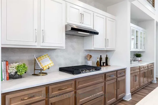 a kitchen with stainless steel appliances granite countertop white cabinets and a stove