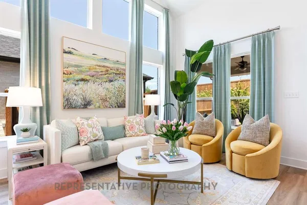 a living room with furniture potted plant and a large window
